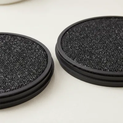 Close-up of activated charcoal filters for ductless range hoods, showing their porous structure and round shape, on a clean surface.